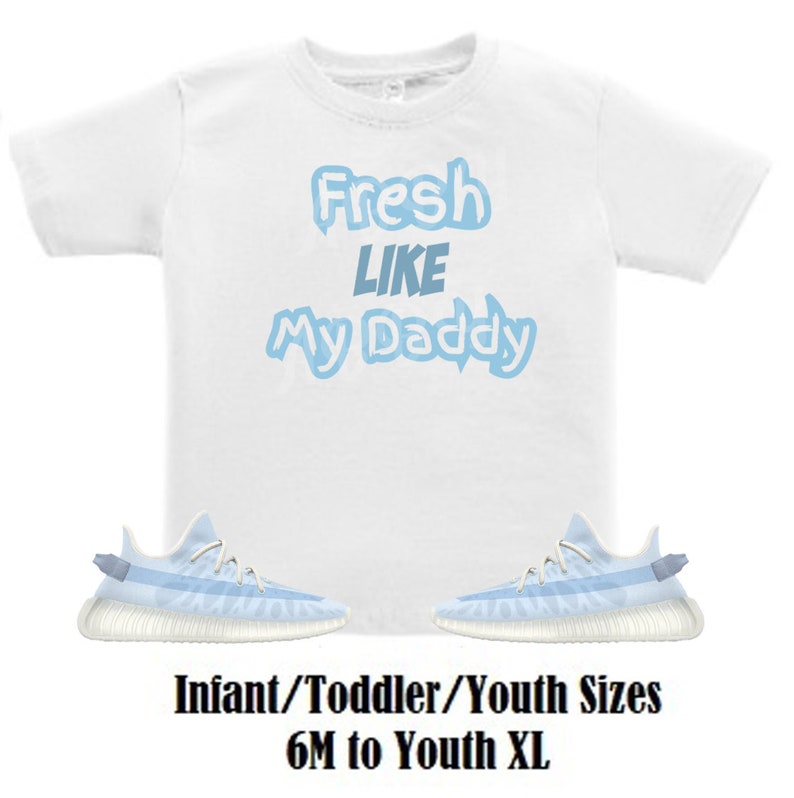 May include: White t-shirt with blue text that reads "Fresh Like My Daddy". A pair of light blue and white trainers are below the shirt. The text "Infant/Toddler/Youth Sizes 6M to Youth XL" is below the trainers.