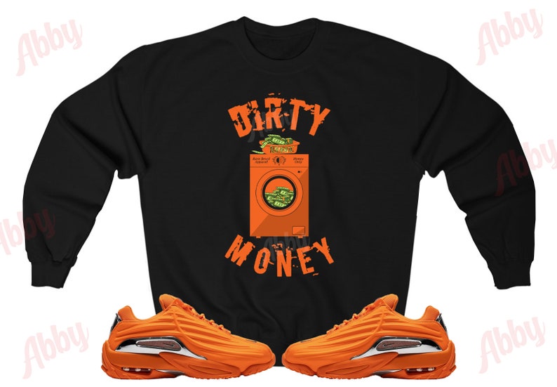 Peut inclure: Sweat-shirt noir avec le texte "DIRTY MONEY" et un graphique d'une machine &agrave; laver remplie d'argent. Le sweat-shirt est associ&eacute; &agrave; des baskets orange et argent.