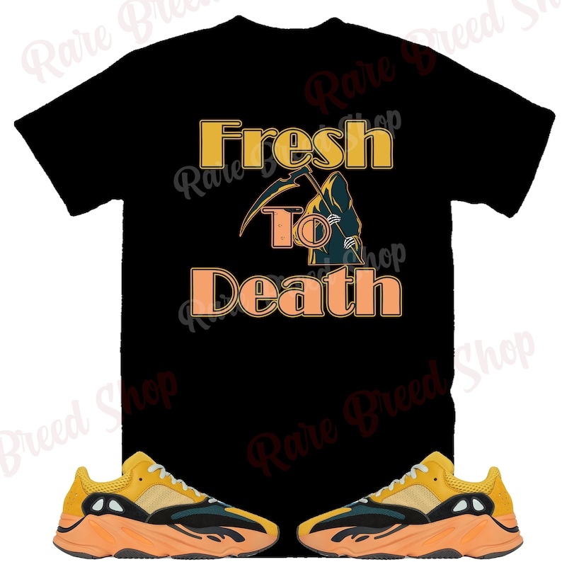 Pu&ograve; includere: Maglietta nera con il testo "Fresh to Death" in arancione e una grafica della Morte. Un paio di scarpe da ginnastica gialle e nere con suole arancioni.
