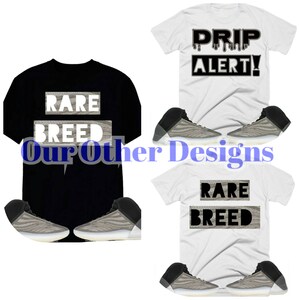 May include: Two t-shirts with different designs. One black t-shirt with the text "RARE BREED" and one white t-shirt with the text "DRIP ALERT!"  Both t-shirts are paired with a pair of grey and white trainers.