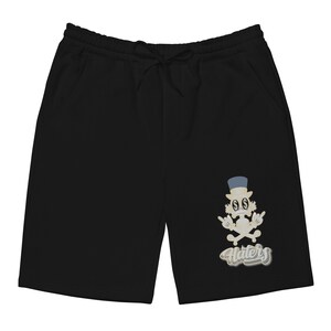 May include: Black sweatpants with a graphic print of a cartoon character wearing a top hat and holding a skull and crossbones. The text "Haters" is printed below the character.