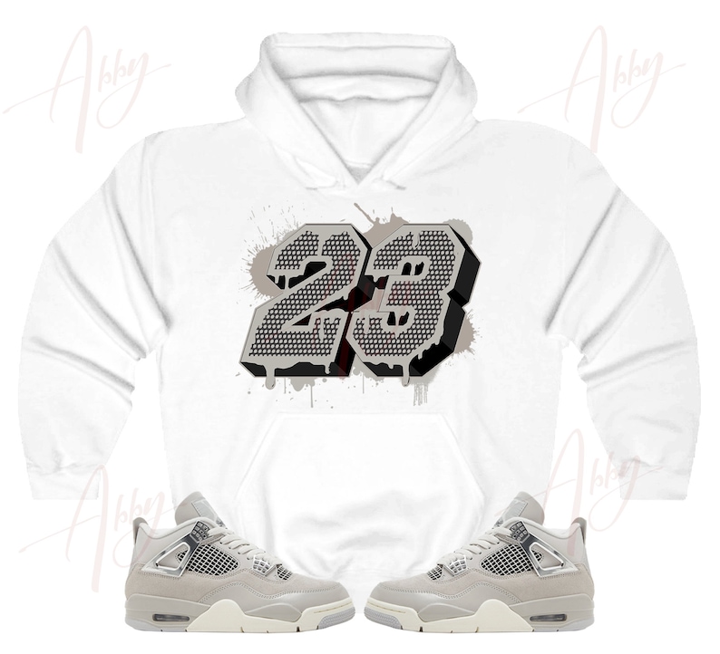 May include: White hoodie with a gray and black number 23 graphic print. The hoodie is paired with gray and white sneakers.
