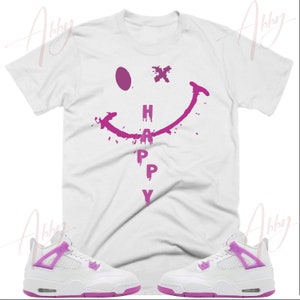 May include: White t-shirt with a pink smiley face graphic and the word "HAPPY" dripping down.  Two white sneakers with pink accents.