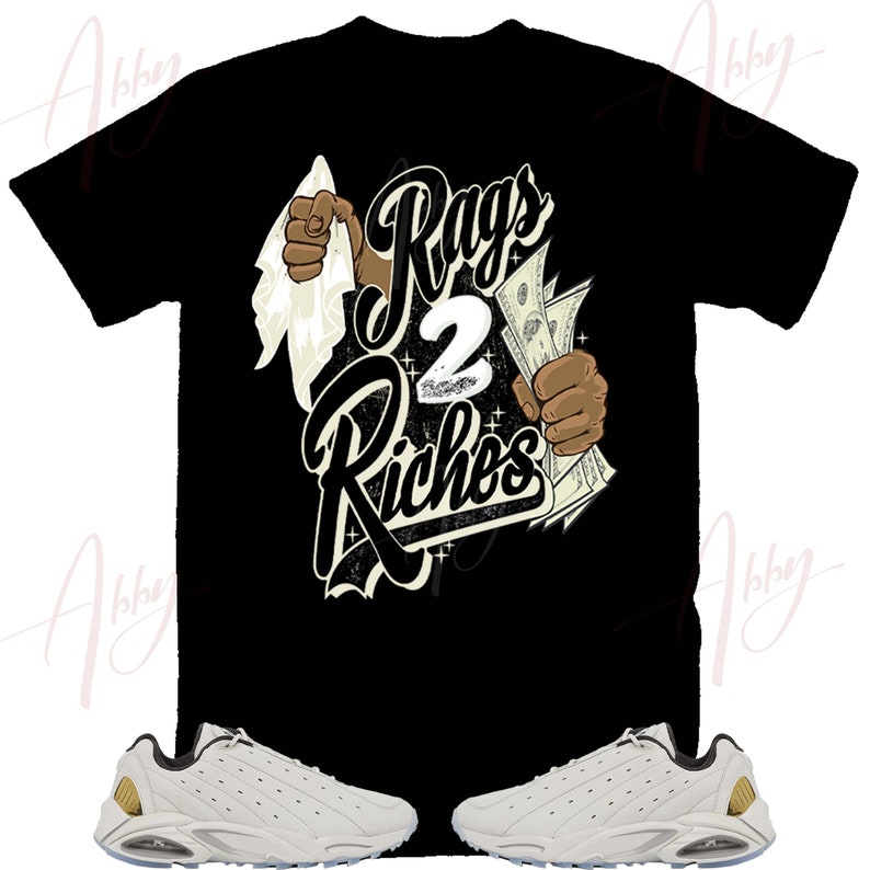 May include: A black t-shirt with the text "Rags 2 Riches" in white and gold lettering. The shirt features a graphic of a hand holding money and another hand wiping away dirt. A pair of white sneakers with gold accents are also pictured.