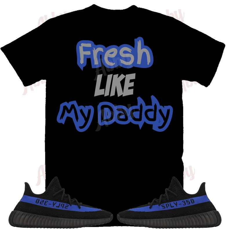 Puede incluir: Camiseta negra con texto azul y gris que dice "Fresh Like My Daddy". Un par de zapatillas negras y azules con el texto "SPLY-350" y "350-Y3J2" en las suelas.
