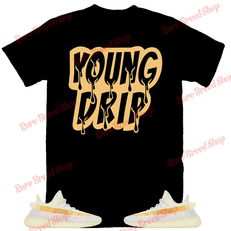 以下が含まれることがあります： 「YOUNG DRIP」という文字がオレンジとイエローの滴るフォントで書かれた黒いTシャツ。白いオレンジ色のスニーカーと合わせています。