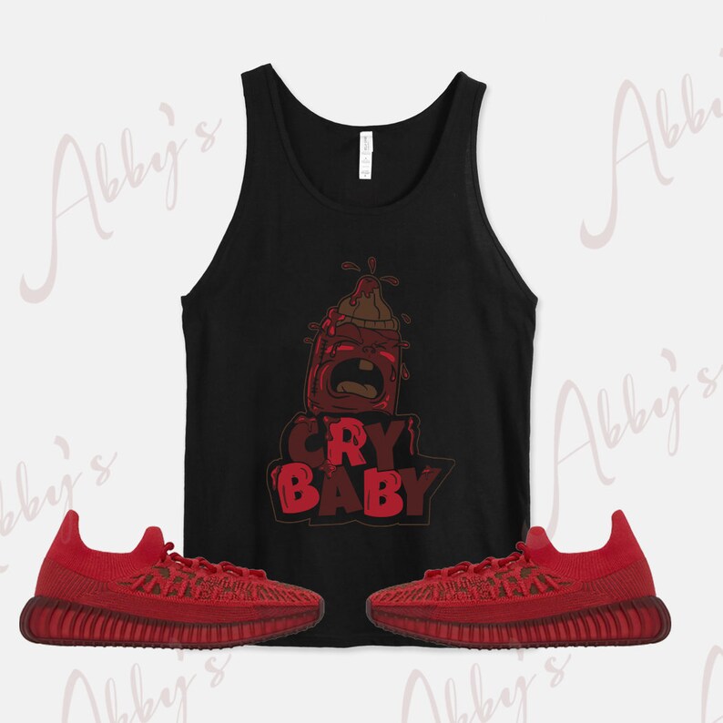 Puede incluir: Una camiseta sin mangas negra con un gr&aacute;fico de biber&oacute;n rojo de dibujos animados y el texto "CRY BABY". Dos pares de zapatillas rojas con detalles negros.