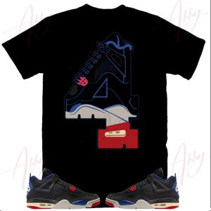 May include: Black t-shirt featuring a graphic of a sneaker design with the number "4" in blue, white, and red. Two black and blue sneakers with red and white accents are displayed below the shirt.