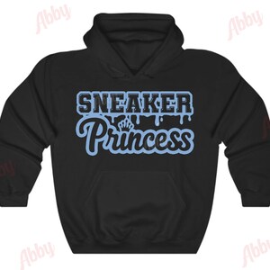 May include: Black hooded sweatshirt with a blue graphic that says "Sneaker Princess" with a crown above the word "Princess".