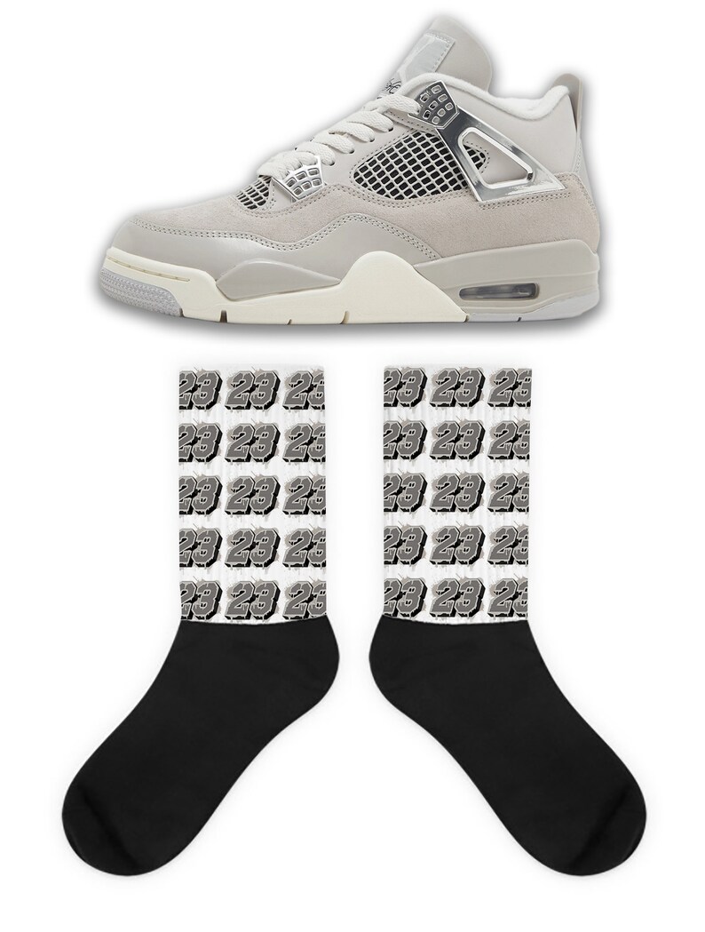 May include: A pair of grey and white sneakers with black socks featuring a repeated pattern of the number 23.