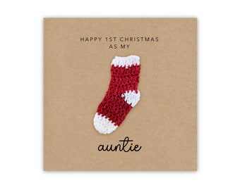 May include: A brown card with the text "Happy 1st Christmas as my auntie" and a red and white knitted sock.