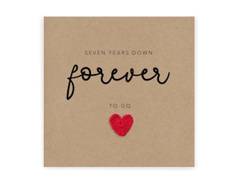 Peut inclure: Une carte marron avec le texte "SEVEN YEARS DOWN forever TO GO" en lettres noires. Un cœur en feutre rouge est attaché à la carte.