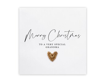 May include: A white card with the text "Merry Christmas to a very special Grandma" in black script. A gold glitter heart is in the center of the card.
