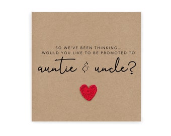 May include: A brown card with the text "SO WE'VE BEEN THINKING... WOULD YOU LIKE TO BE PROMOTED TO auntie & uncle?" and a red crocheted heart.