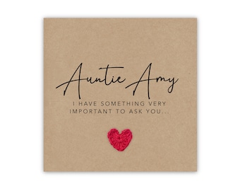 May include: Auntie Amy card with a red heart. The card is a light brown color with black script that reads "Auntie Amy" and "I HAVE SOMETHING VERY IMPORTANT TO ASK YOU..."