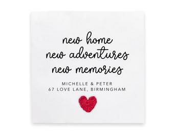 May include: A white card with black text that reads "new home new adventures new memories" with the names "Michelle & Peter" and the address "67 Love Lane, Birmingham". A red crocheted heart is in the bottom center of the card.