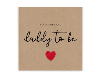 Puede incluir: Una tarjeta marrón con el texto "To a special daddy to be" en letra cursiva negra. Un pequeño corazón rojo está pegado a la tarjeta.