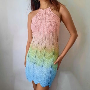 May include: A crochet halter dress with a rainbow ombre design. The dress is made from soft, lightweight yarn and has a relaxed fit.