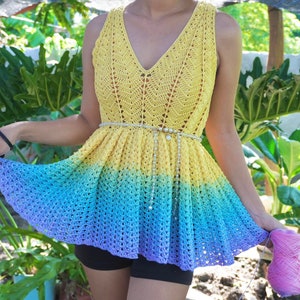 May include: A crochet top with a rainbow ombre design. The top is sleeveless and has a V-neck. The top is made with a delicate crochet stitch and has a flowing, feminine silhouette.