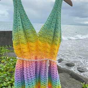 May include: A rainbow crochet top with a beaded belt. The top is sleeveless and has a V-neckline. The top is made of a soft, lightweight yarn and is perfect for summer.