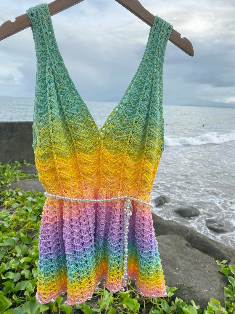 May include: A rainbow crochet top with a beaded belt. The top is sleeveless and has a V-neckline. The top is made of a soft, lightweight yarn and is perfect for summer.