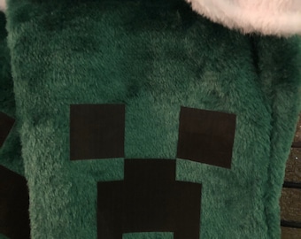 Könnte beinhalten: Grüner Weihnachtsstrumpf mit einem schwarzen Minecraft Creeper-Gesichtsdesign.