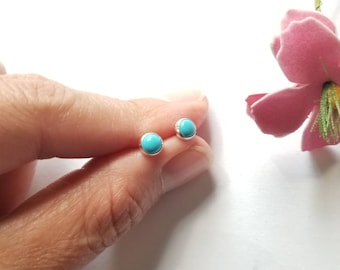 May include: A pair of silver stud earrings with turquoise stones.