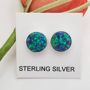 May include: A pair of sterling silver stud earrings with round green and blue opal stones.