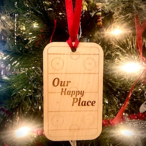 Ornamento/Etiqueta de presente - formato de pista de hóquei; pista de hóquei de um lado com a frase Our Happy Place, personalizada no verso