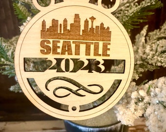 Ornament - Seattle Skyline cityscape. 4" X 4.75" wood ornament with choice of year.  Great souvenir or memento from your favorite city.