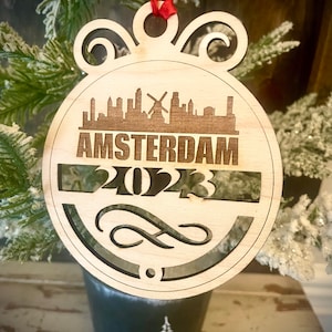 Ornament - Amsterdam Skyline cityscape. 4&quot; X 4.75&quot; wood ornament with choice of year.  Great souvenir or memento from your favorite city