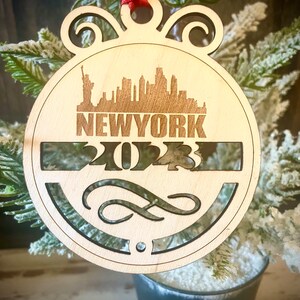 Ornament - New York Skyline cityscape. 4&quot; X 4.75&quot; wood ornament with choice of year.  Great souvenir or memento from your favorite city.
