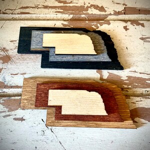 Nebraska 3-layer stacked state laser cut wood magnet available in brown tones or gray tones.