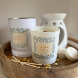Kaars cadeau. Daisy Daisy cadeaupakket met daarin een kaars met houten lont van 30 cl en een pakje met 4 grote sojawasmelts. Keramische brander kan worden toegevoegd.