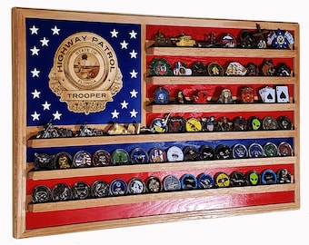 May include: A wooden display case shaped like the American flag, featuring a blue field with white stars and red and white stripes. It holds various collectible coins and small figurines, with a "HIGHWAY PATROL STATE OF FLORIDA TROOPER" emblem.