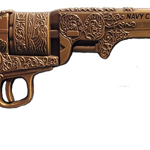 May include: A bronze-colored decorative revolver with intricate scrollwork and the text "NAVY CHIEF NAVY PRIDE." The handle features the letters "USN" and anchors. The overall design is ornate and detailed.