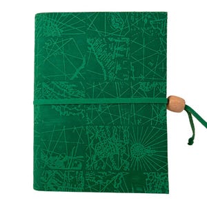 Può includere: Un diario verde con un design a mappa. La copertina è verde scuro con un motivo ripetuto di linee e forme. Un elastico verde avvolge il diario, e una perla di legno e un cordino verde lo assicurano. Il diario è chiuso.