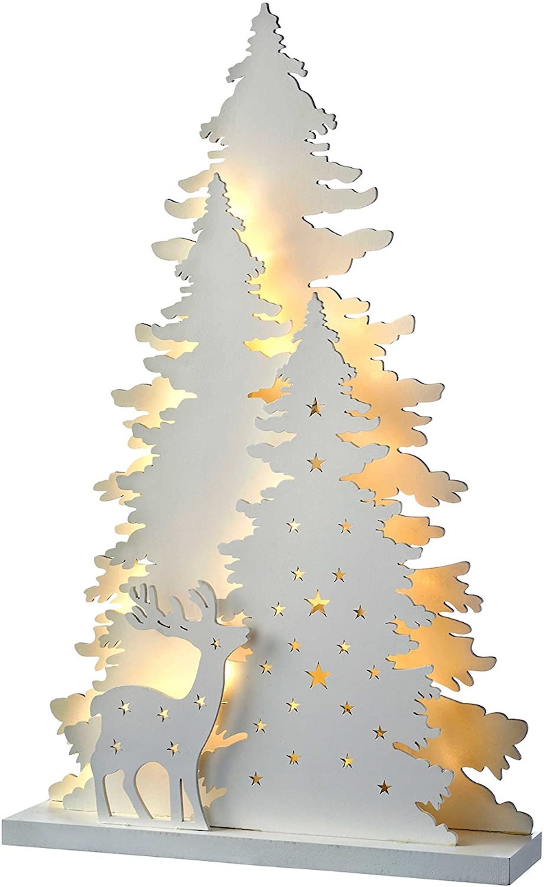 May include: White wooden Christmas tree silhouette with a deer and stars cut out. The tree is illuminated with warm white LED lights.