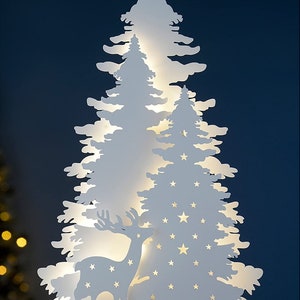 May include: White wooden Christmas tree silhouette with a deer and stars cut out. The tree is illuminated with warm white LED lights.
