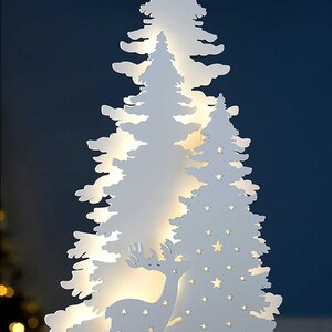 May include: White wooden Christmas tree silhouette with a deer and stars cut out. The tree is illuminated with warm white LED lights.