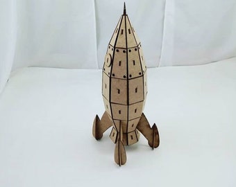 Op de afbeelding: Een houten raketmodel met een bruine afwerking. De raket heeft een puntige neuskegel en drie vinnen. Het model is gemaakt van veel kleine stukjes die aan elkaar zijn gelijmd.
