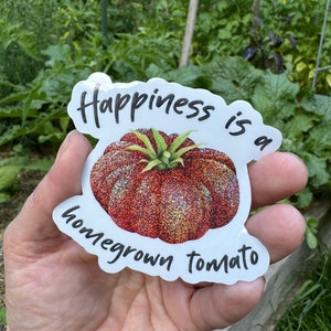 May include: A white sticker with a red and orange glitter tomato illustration and the text "Happiness is a homegrown tomato".