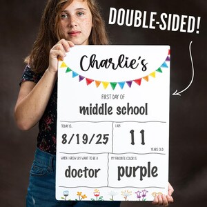 May include: A white, double-sided sign with the text "Charlie's" and "First Day of Middle School." The sign includes the date "8/19/25," the age "11," and the words "doctor" and "purple." Colorful bunting and floral accents decorate the sign.