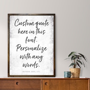 May include: A framed print with a white background and black text that reads "Custom quote here in this font. Personalize with any words. AUTHOR, DATE, ETC."