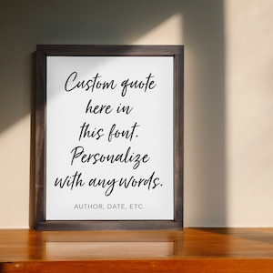 May include: A framed canvas print with a white background and black text that reads "Custom quote here in this font. Personalize with any words. AUTHOR, DATE, ETC."