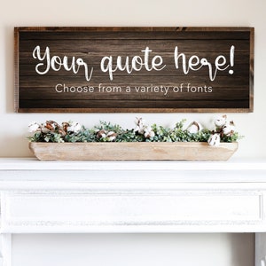 Pode incluir: Uma placa de madeira rústica com o texto "Your quote here! Choose from a variety of fonts". A placa está pendurada acima de uma lareira branca com uma tigela de madeira cheia de algodão e vegetação.