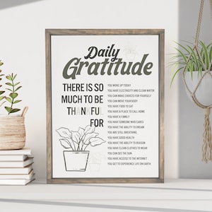 May include: A printable wall art design with a gray background and black text. The text reads "Daily Gratitude" and lists things to be thankful for, such as "You woke up today", "You have electricity and clean water", and "You get to experience life on Earth".