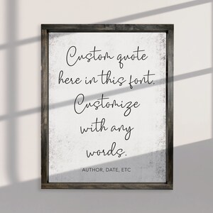 May include: A white sign with a black wooden frame. The sign has a distressed white background and black text that reads "Custom quote here in this font. Customize with any words. AUTHOR, DATE, ETC"