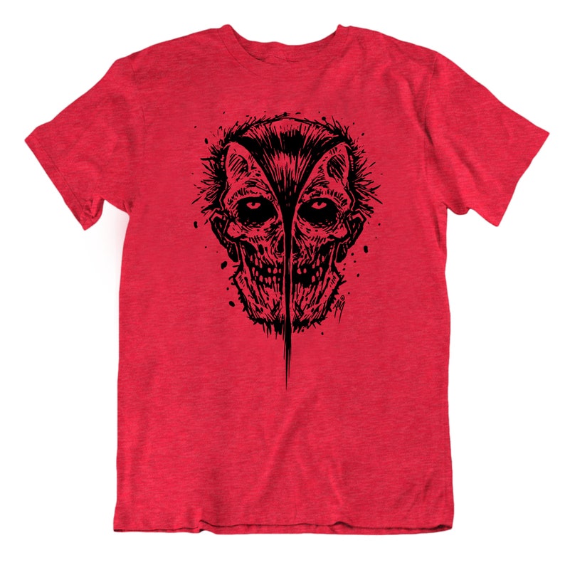 May include: Red t-shirt with a black and white graphic print of a skull with a split face.