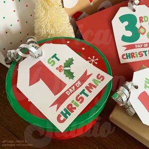 May include: A set of Christmas countdown tags with red, green, and white colors. The tags feature the numbers 1 and 3 with the text "1st Day of Christmas" and "3rd Day of Christmas".